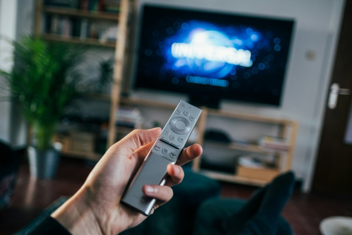 TV 앞에서 리모컨을 든 손